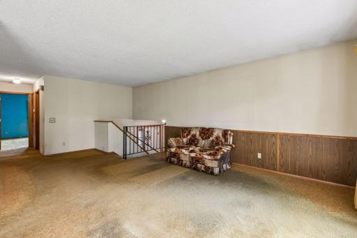 Another view of the living room facing the large front entry and main level bath / bedrooms