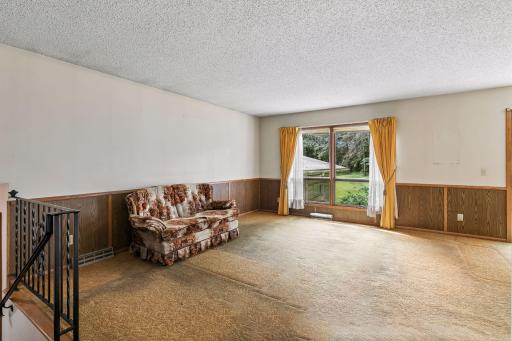 Large living room with windows to the backyard
