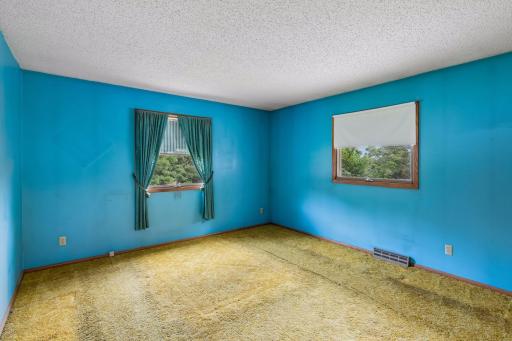 1 of 2 main level bedrooms. 2 windows and a double closet.