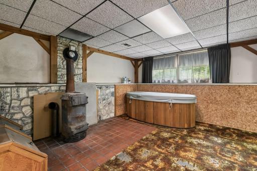 Lower level family room (woodburning stove is not currently hooked up). Small hot tub can stay or be removed.