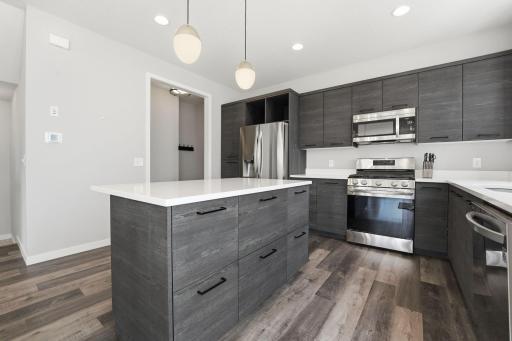 Gorgeous kitchen with plentiful storage, stainless steel appliances, and quartz counters.
