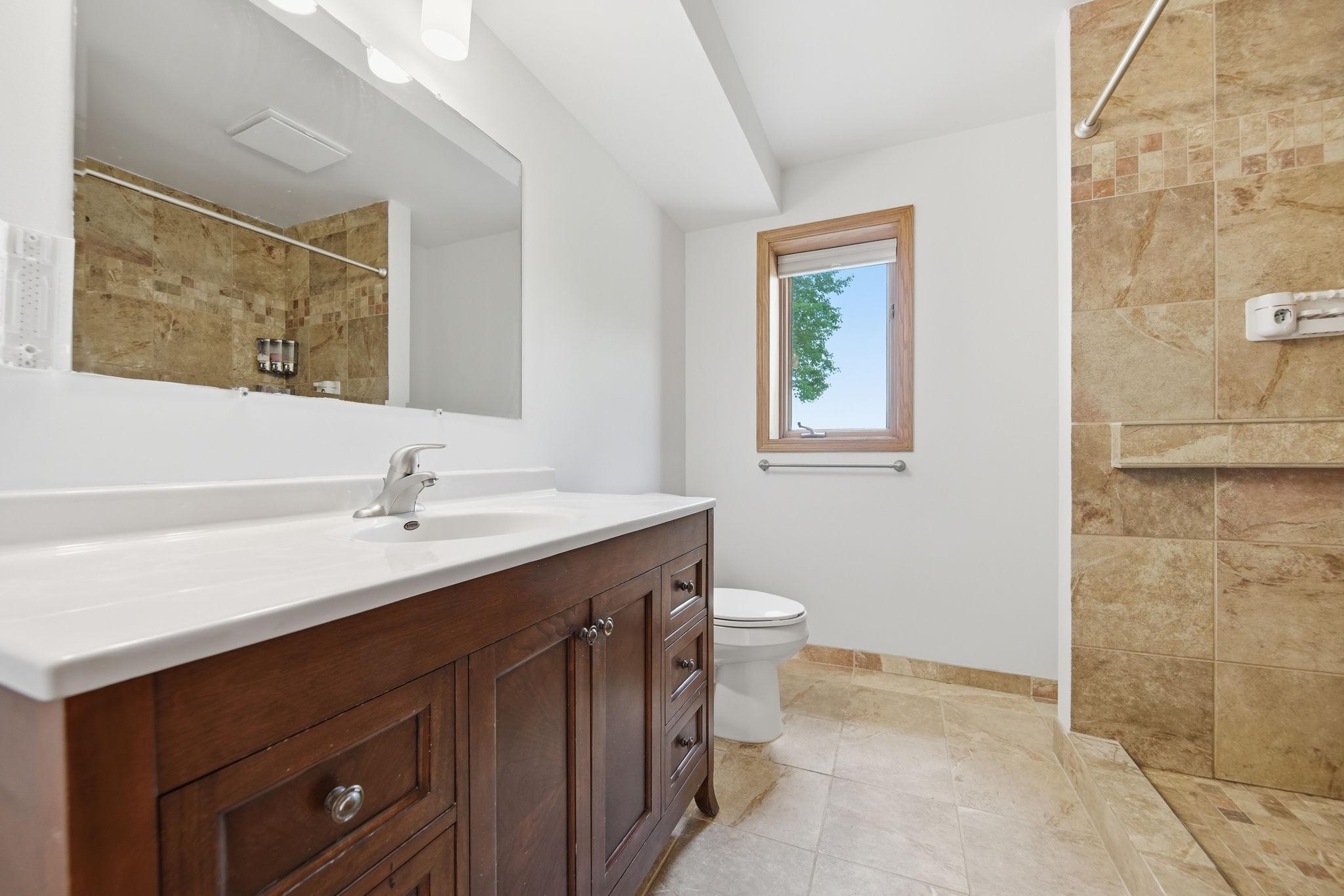 This is the lower-level 3/4 bath. You'll appreciate a taller vanity and tiled walk-in shower.