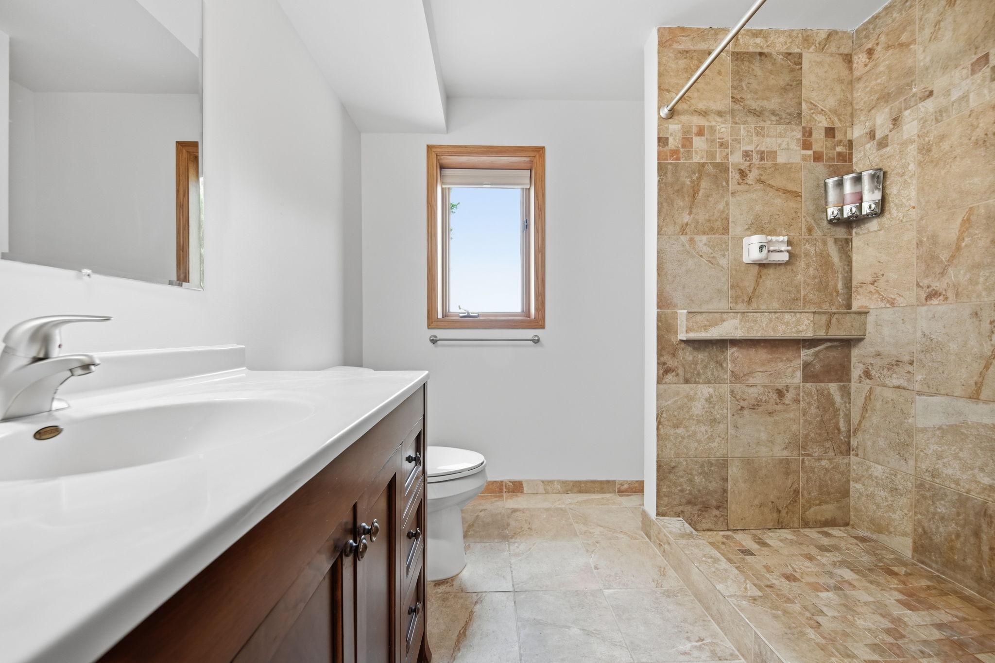 The shower is oversized, and you'll love the natural daylight window overlooking the backyard. Note: the laundry/utility room is directly adjacent to this bathroom.