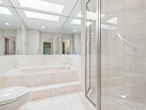 Separate tub and shower with glass enclosure.