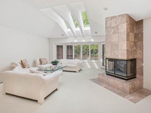 Vaulted living room with skylights and a wall of windows.