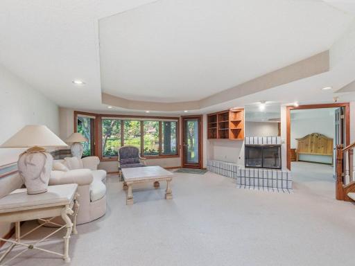 Lower level amusement room - beautiful ceramic 3 sided fireplace. Door to walk out level patio.