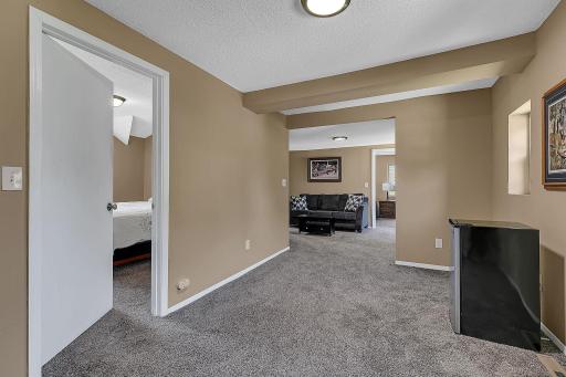 Top of the stairway, front bedroom door on the left, family room in the background. New carpeting and fresh paint.