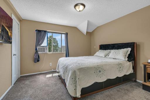 This is the upstairs front bedroom. The new Goodman Central Air unit was installed on 7/8/2026. The flat screen, wall mounted TV will convey with the home. It is working and has a remote, but no warranty. New carpet upstairs.