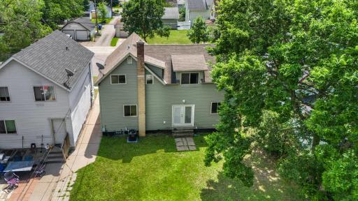 Elevated view of the rear of the home and large shade tree in back yard.