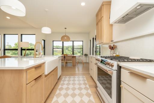 This kitchen is a 10/10!! Custom cabinetry and vent hood along with the farmhouse sink, and gas range