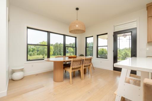 Dining area with expansive windows overlooking the private backyard
