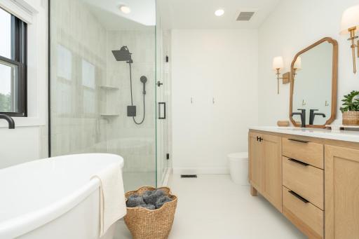 Thoughtfully designed primary bath with a freestanding soaking tub and oversized glass shower.