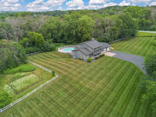 Lush green grass surround the open area of the land around the home.