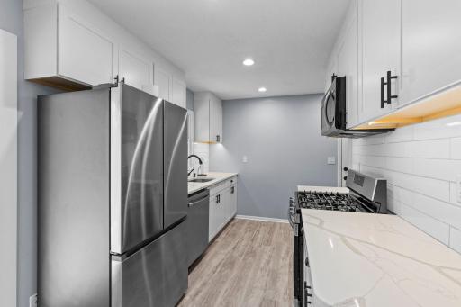 Beautifully updated, the kitchen includes granite counters, tile backsplash, stainless appliances and a gas range