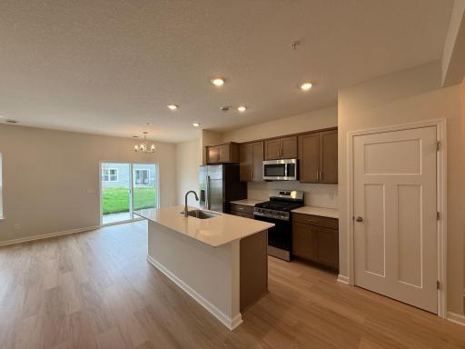 A look-out center quartz kitchen island provides plenty of working space and a sizable nearby pantry provides plentiful storage.