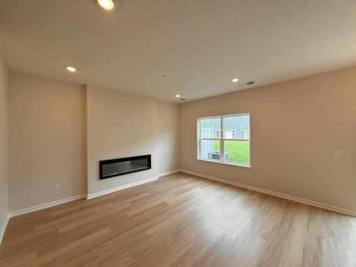 Living area provides natural light, an electric fireplace and space for a variety of furniture setups.
