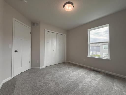 Adjacent secondary bedrooms provide space for family, guests, or a home office