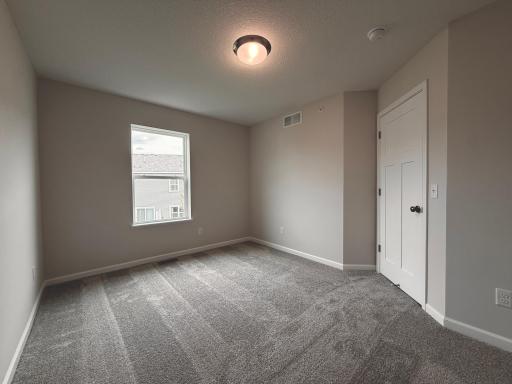 Adjacent secondary bedrooms provide space for family, guests, or a home office