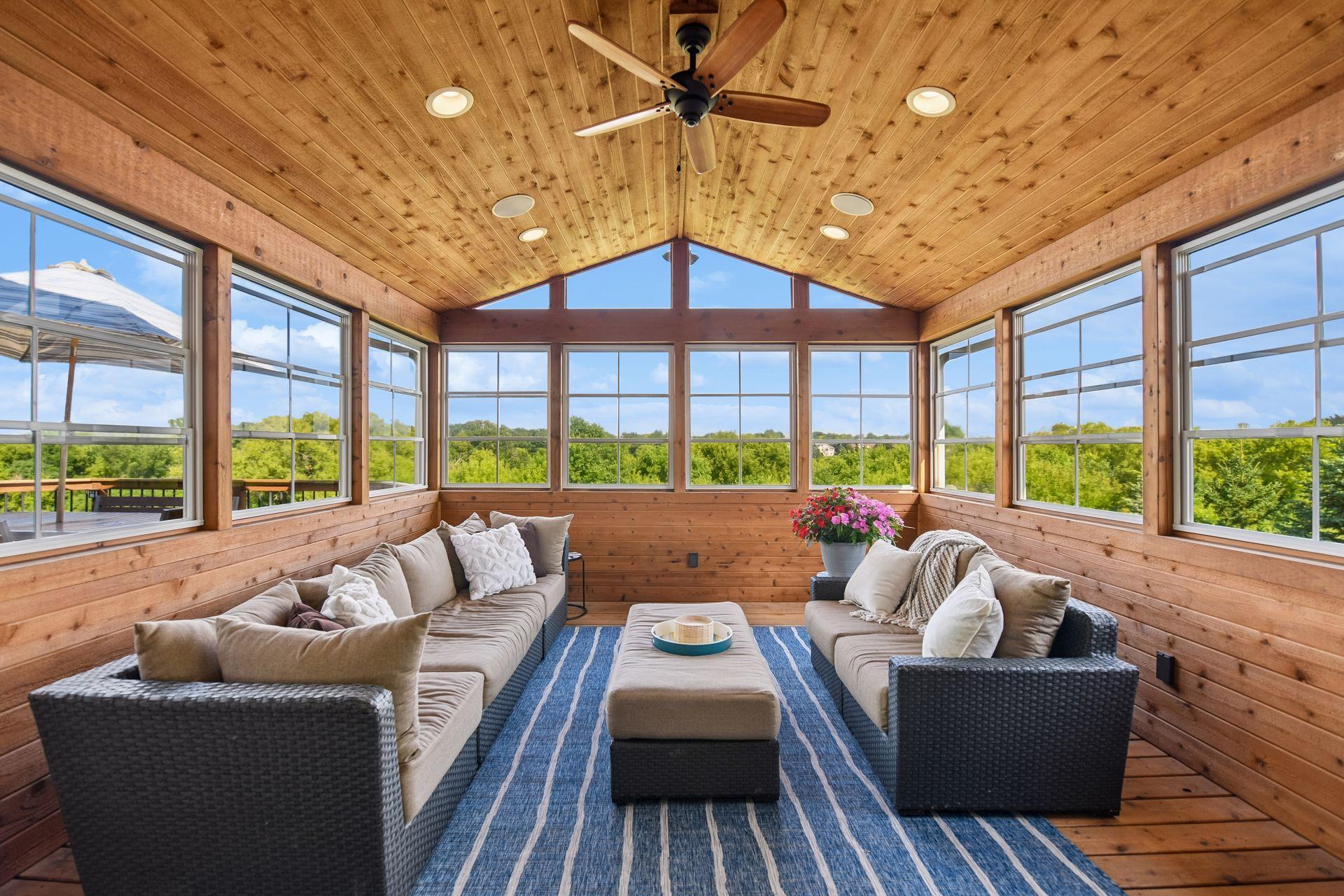 Cedar-lined three-season porch with a vaulted ceiling, ceiling fan, surround sound speakers and screened windows on three sides overlooking the wetlands.