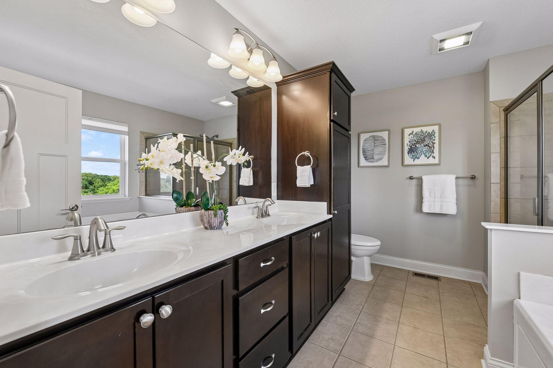 Primary bath with a double vanity, tiled shower and soaking tub