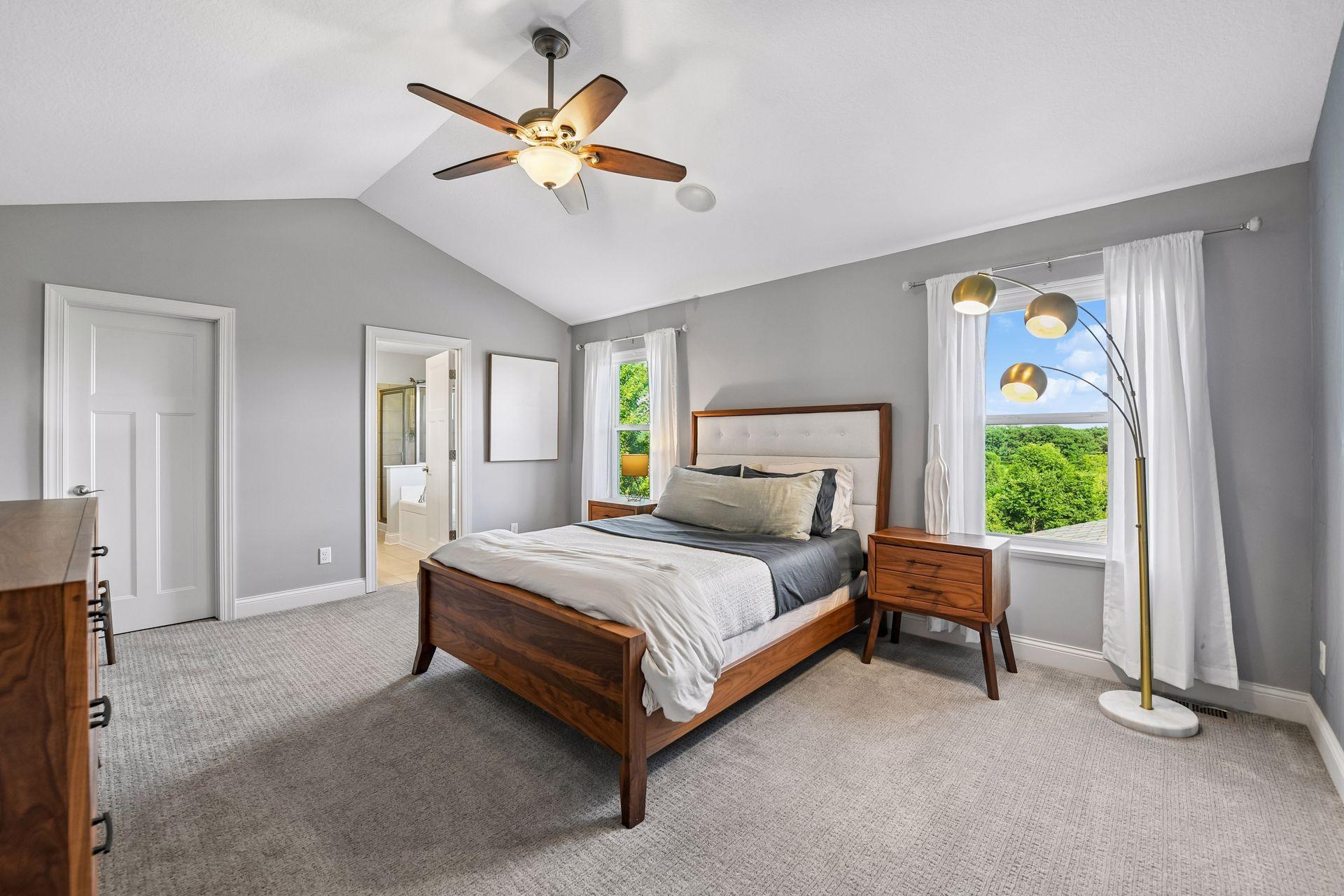 Primary bedroom with vaulted ceiling, built in speakers, and large walk in closet