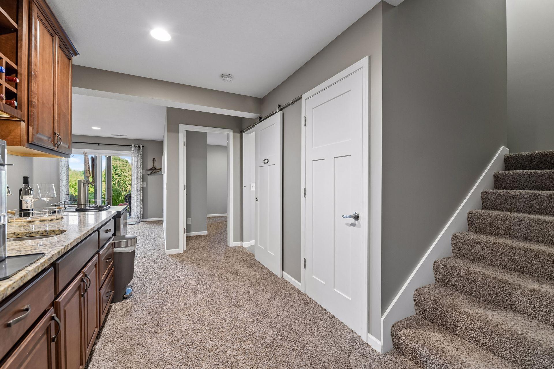 Lower-level landing beside the wet bar, with the staircase to the main level.