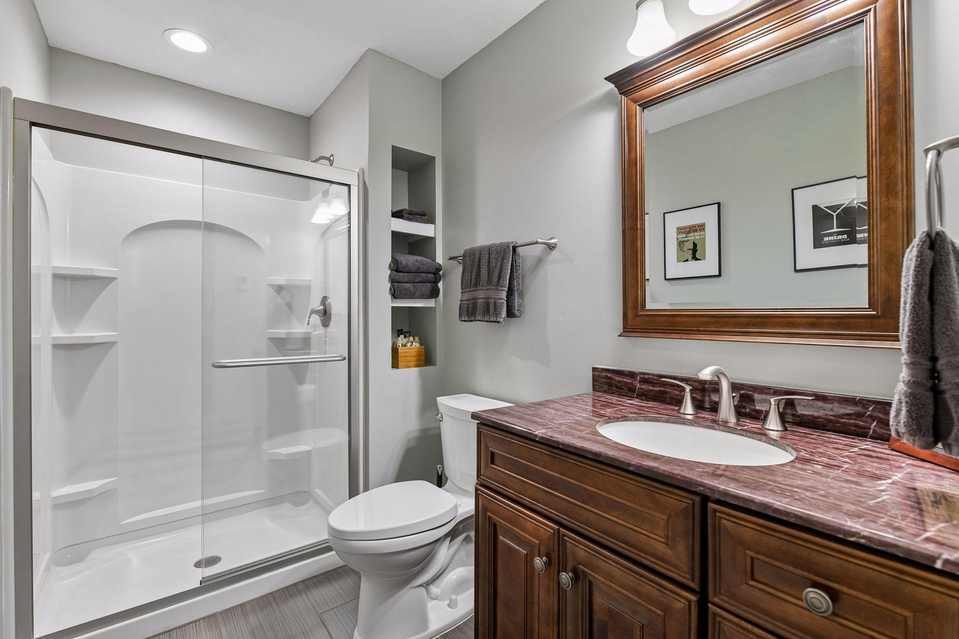 Lower-level full bath with a glass walk-in shower and vanity.