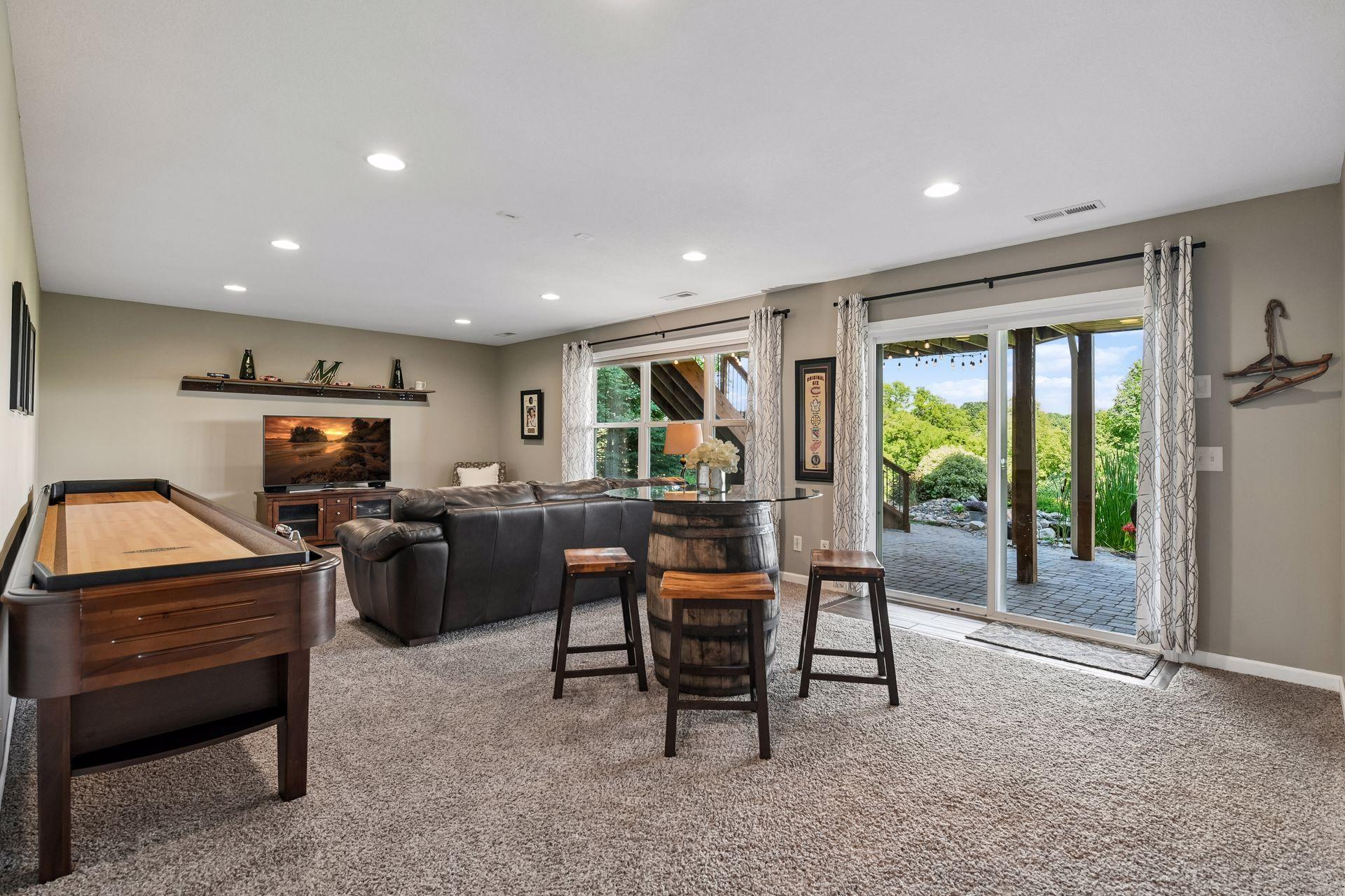Walkout rec room with recessed lighting, opening directly to the covered lower patio.