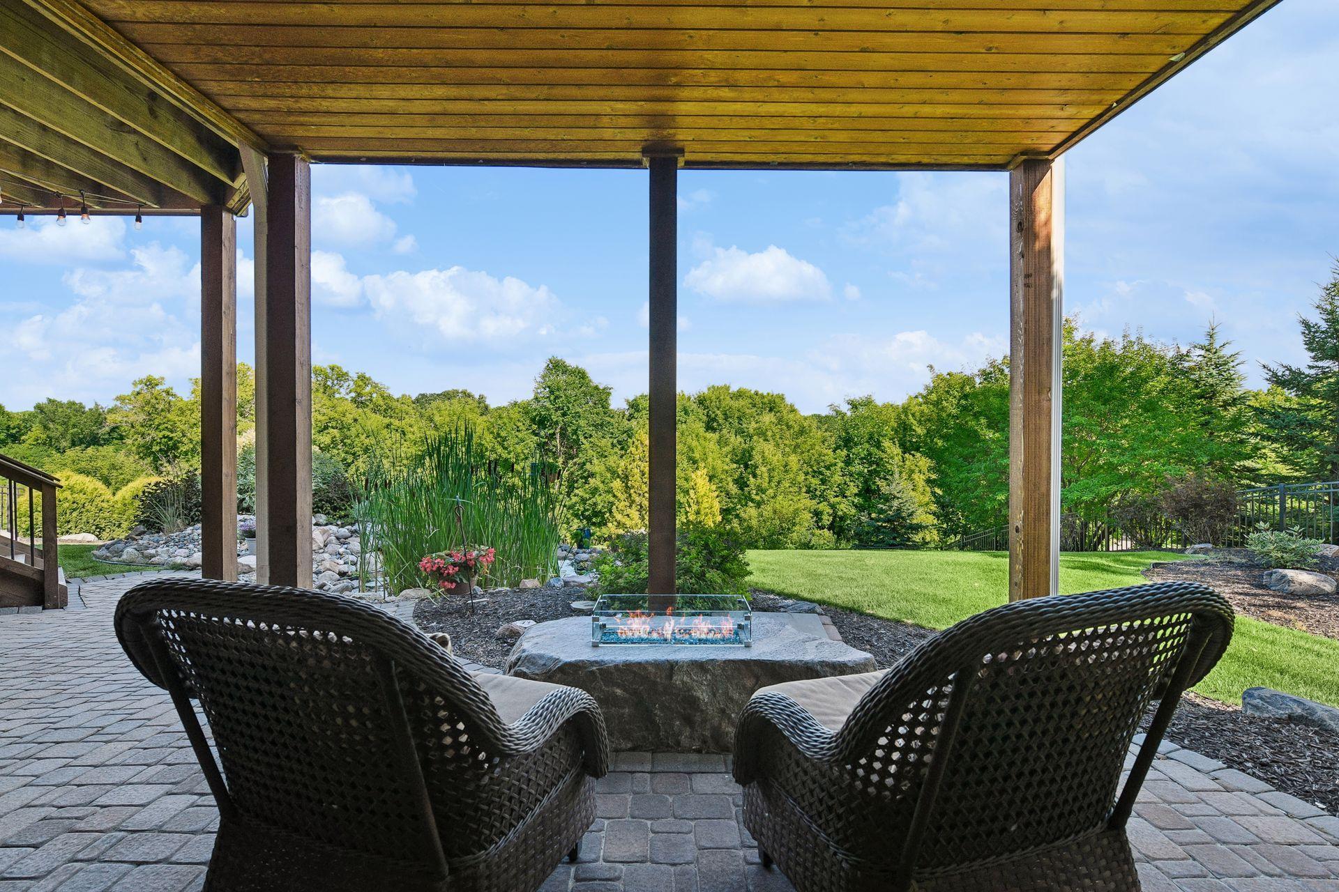 Covered patio with a built-in propane fire feature and open views to the backyard.