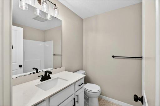 Main Level Bathroom. Photo taken of another home with similar plan and finishes.