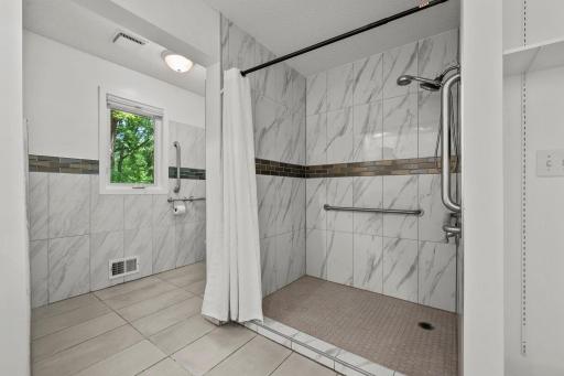 Tiled walls and floor and hand grip assistance bars
