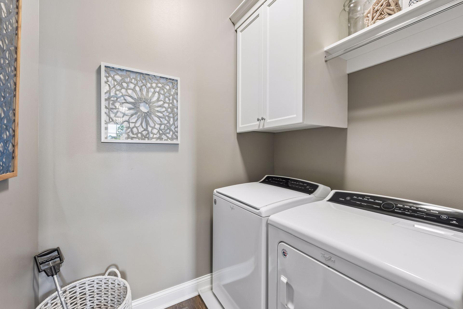 Laundry room with a washer, dryer and cabinet storage. Ideal for organization while doing your laundry.
