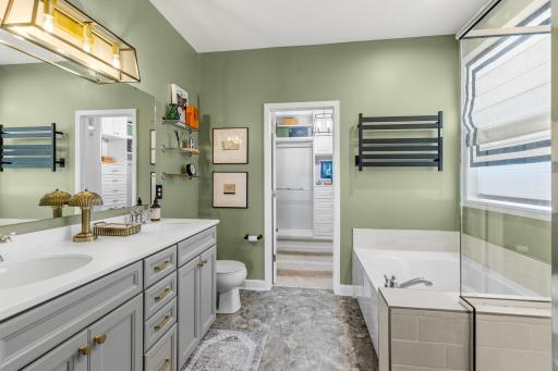 The primary bath has dual sinks, soaking tub and a towel bar warmer. You access the custom walk-in closet through the bathroom.