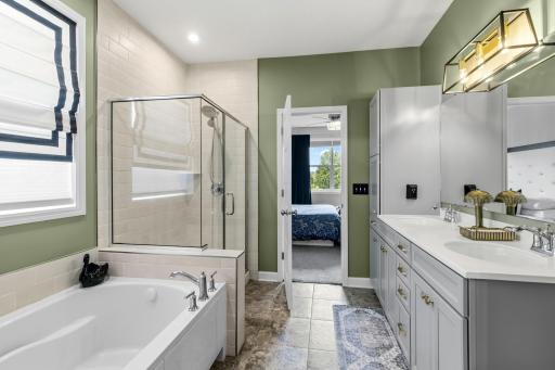 The other side of the primary bathroom. You can see the separate tiled shower and all of the additional bathroom storage space.