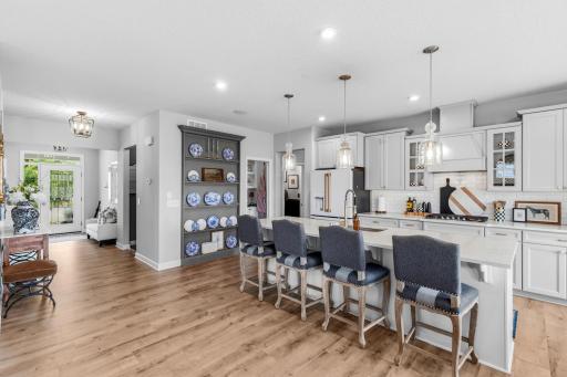 Notice the beautiful upgraded front door. The center island is large and is roomy with four comfy stools.