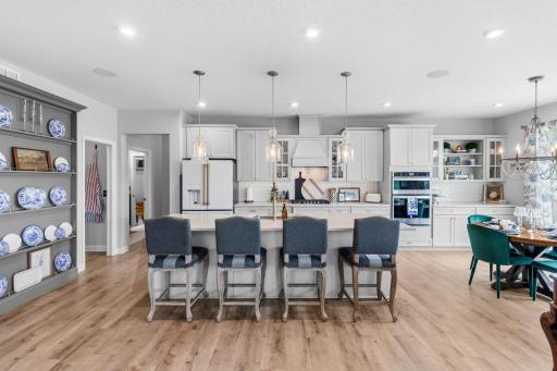 Notice the custom plate wall to display whatever you choose. There is a full wall of cabinetry & granite countertops with a beautiful range hood and subway tiled backsplash.