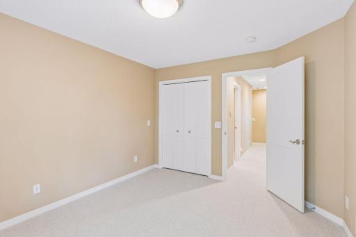 The central corridor connecting the three bedrooms accommodates a full bathroom, large storage center, and a separate laundry closet.