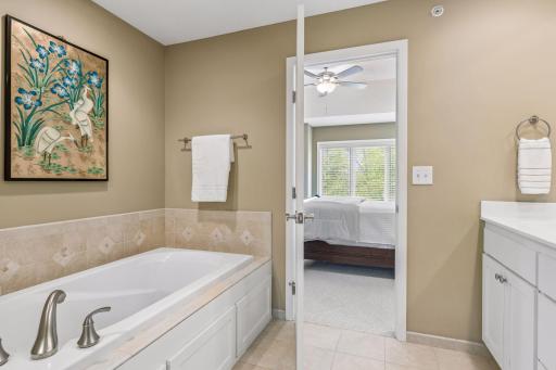 The neutral tile surrounding the soaking tub adds an elegant, spa-like, touch.