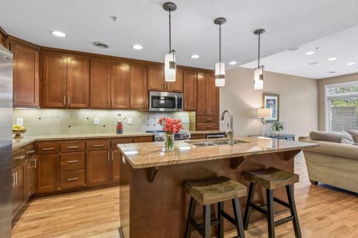 At the heart of the home is a beautifully detailed kitchen featuring a neutral tile backsplash and granite counters.