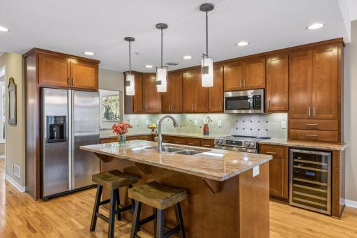 To the right of the refrigerator is the pass-through window peeking into the formal dining room/flex space. Note the under-counter beverage refrigerator.
