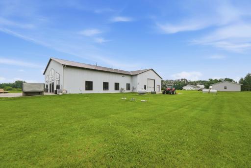 The rear elevation showcases the thoughtfully designed lodge, featuring an additional overhead garage door for easy access to the heated attached garage, expansive outdoor living spaces, and seamless functionality.