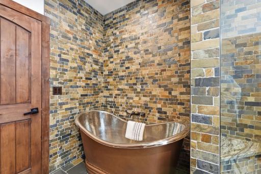 The private owner's suite offers a spa-inspired retreat complete with a copper soaking tub, oversized shower, dual vanities, and private water closet with bidet.