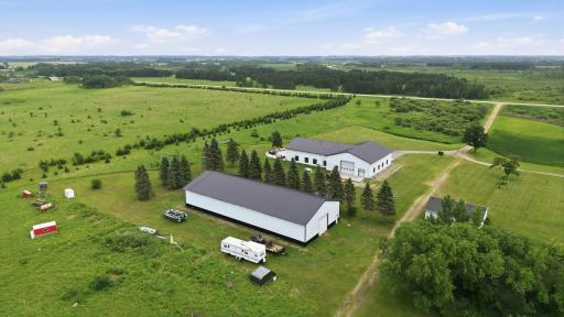 The impressive rear elevation highlights the scale of the custom lodge, heated attached garage, and thoughtful design built for both luxury living and year-round recreation, plus the 60 x 100 outbuilding.