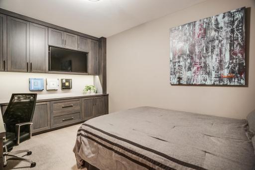 The second bedroom with built-in cabinetry offers additional versatility for an office or guest room.