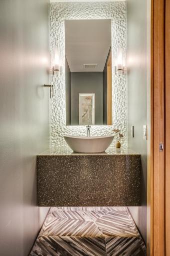 The main level half-bathroom is well-positioned in the unit and features stunning finishes.