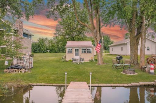 The lake life you've been dreaming of. Your private dock, level shoreline, mature shade trees, fire pit, and quiet bay create the ideal setting for swimming, boating, fishing, and gathering with family and friends all summer long.