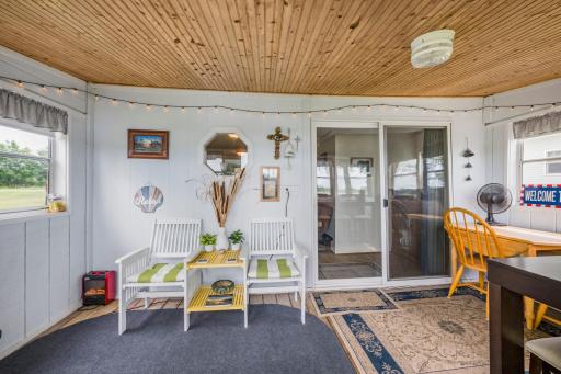 Your favorite gathering spot. With panoramic lake views, warm wood ceilings, and plenty of room to relax or entertain, this inviting porch is the perfect place to unwind, read a book, or enjoy meals with family and friends after a day on the water.