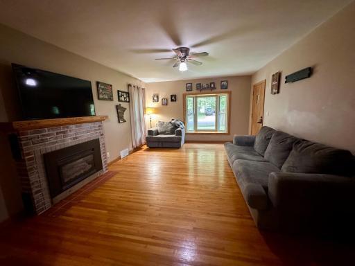 Large living room space features brick fireplace...