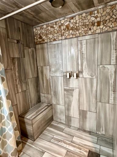 Primary bath in lower level features custom rain shower and tile work.