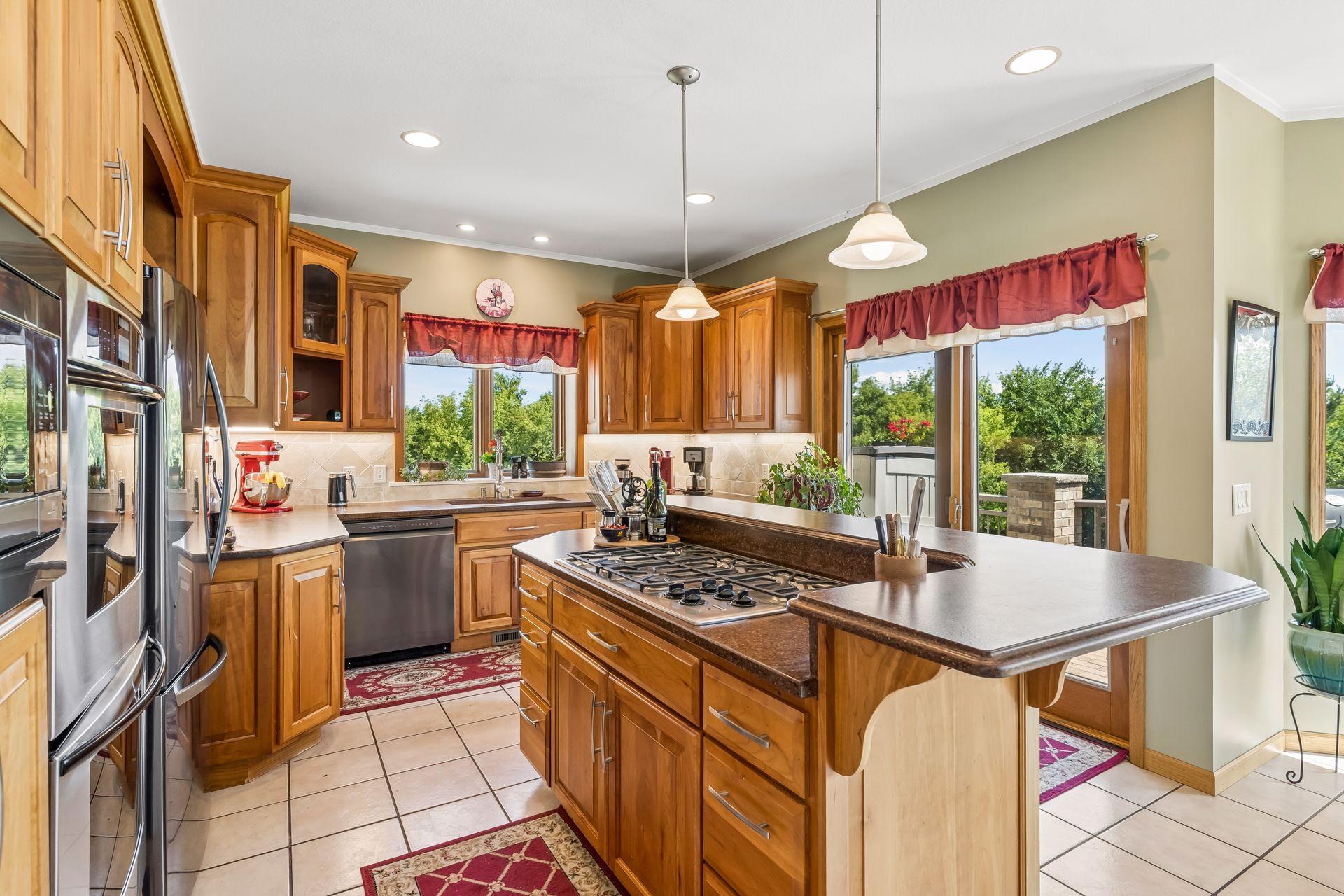 Another perspective of the kitchen highlights the 5 burner gas cooktop, double wall oven, ample counter space and sliding doors leading to the deck.